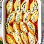 stuffed shells with marinara and ricotta cheese sprinkled with parsley