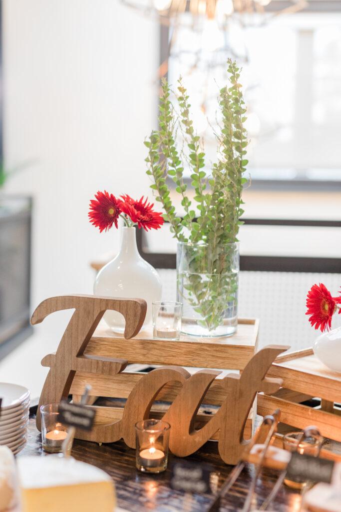 eat wood sign with red flower in a white vase